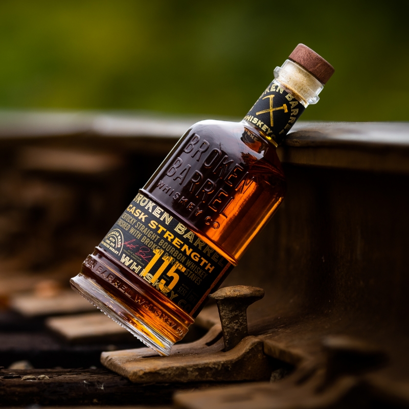 broken barrel bottle leaning against train track