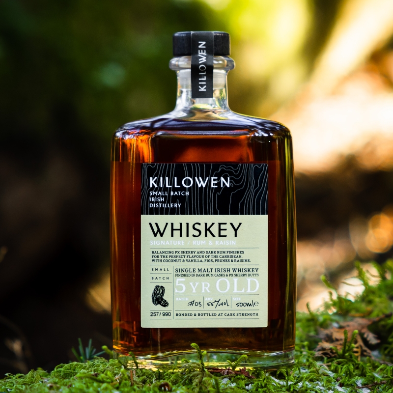 2022_11_08_Killowen11 killowen signature rum and raisin whiskey on a piece of wood with green leaves in the background