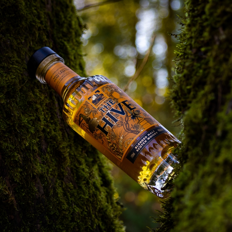 wemyess blended malts the hive bottle in between two mossy tree stumps